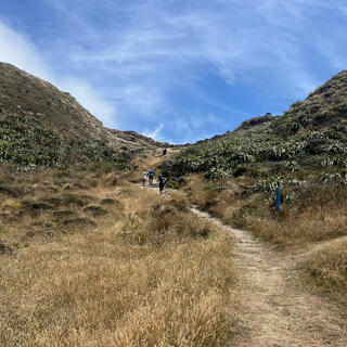 With hands on hips, walkers struggle up the steep path.