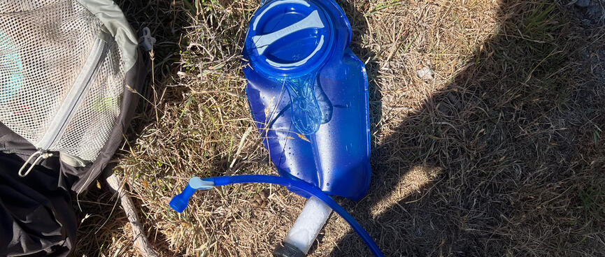 A blue Camelbak hydration bladder with attached drinking hose and LifeStraw 2-stage filter.