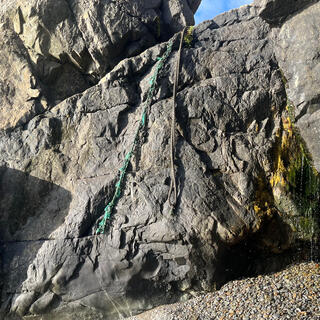 Two ropes hang down the face of a wide sloping rock.