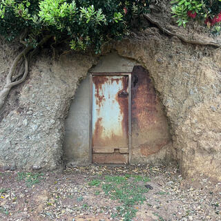 A metal door leads inside the hillside.