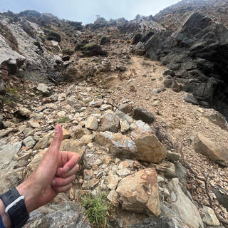 Giving a thumbs-up at the bottom of a loose rocky descent.