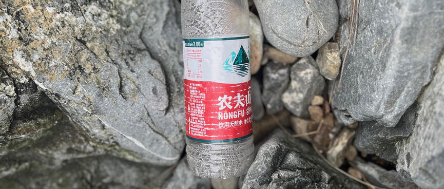An empty plastic bottle labelled ʼNongfu Springʼ.