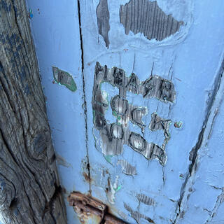 A rusty bolt below an engraved instruction to ʼPlease lock doorʼ.