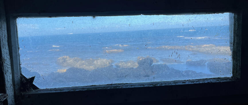 The rocky coast viewed through a narrow perspex window.