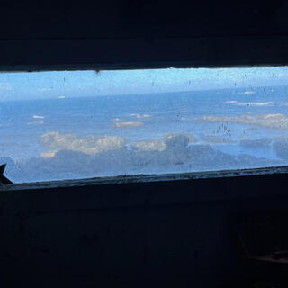 The rocky coast viewed through a narrow perspex window.