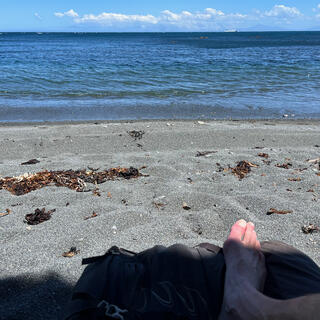 A shaded leg and the shingle beach and sea beyond.