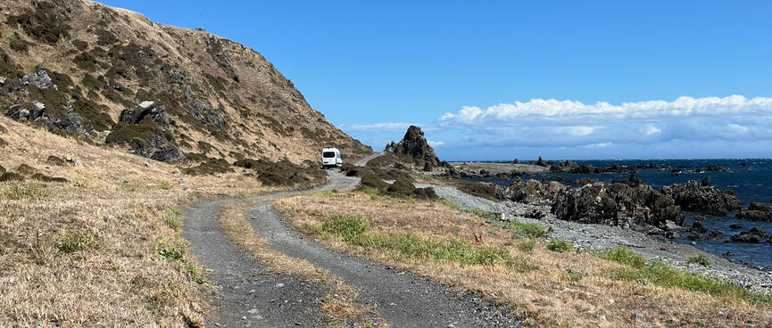 A large white campervan on the coastal road.