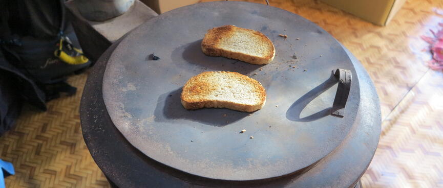 Two pieces of toast sit on top of a round metal stove top.