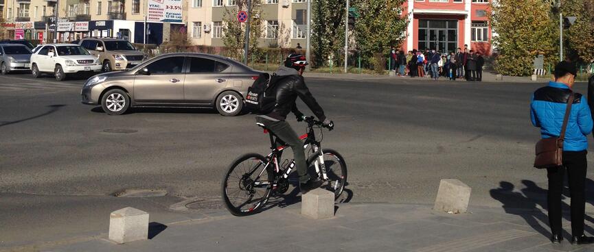 A manʼs bike, helmet, bag and jacket share a black, white and red colour scheme.