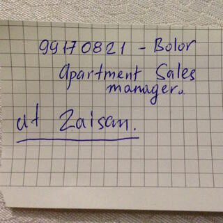 The name and number of a real estate agent is scrawled on graph paper.