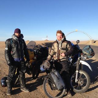 Two men in motorcycling gear pose with our three loaded touring bikes.