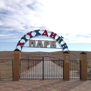 A metal half circle above the gate is adorned with blue, red and white lettering.