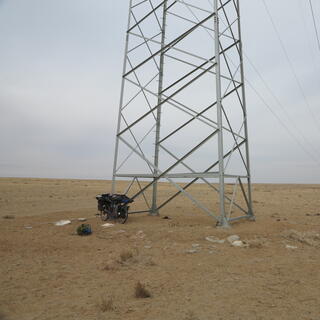 An infinitely long line of power pylons in an otherwise barren landscape.