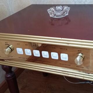 The front panel of a bedside table features six switches and two dials.
