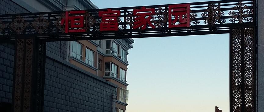 Patterns and red lettering on steel girders forming a gateway.