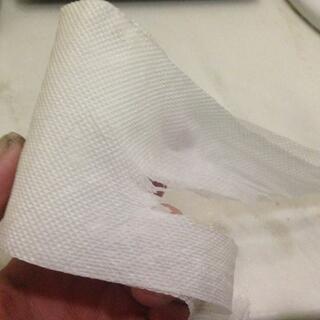 A horizontal tear in a strip of toilet paper.