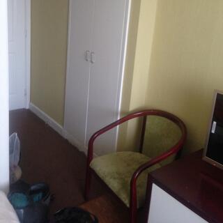 Yellow walls, white wardrobe doors and a sitting chair.