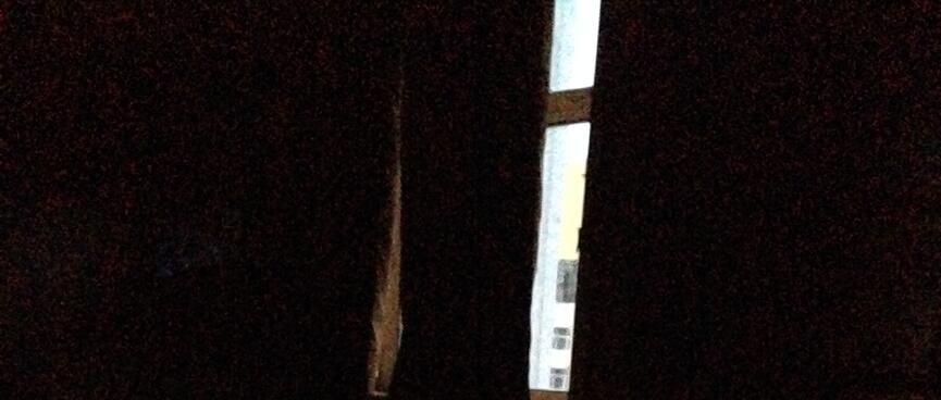 A thin strip of daylight is visible through the parted curtains.