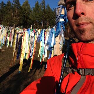 I pose in front of a line of prayer flags.