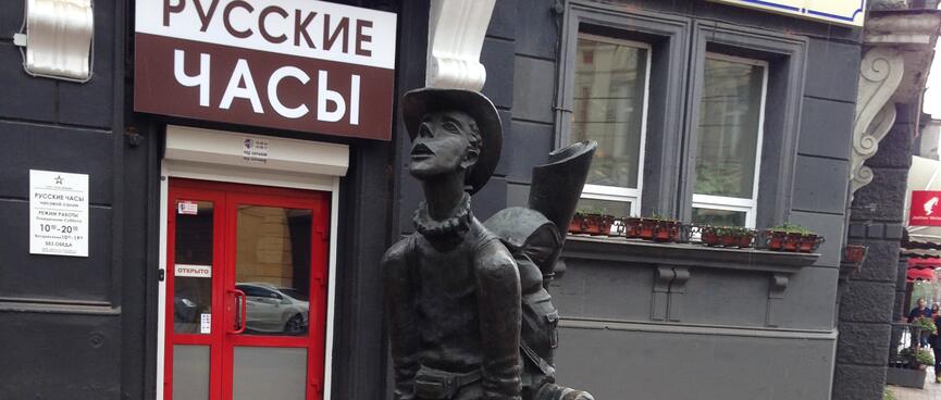 A metal statue of a boy wearing a hat and a backpack.