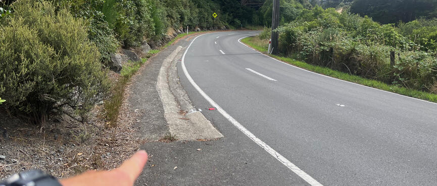 A foot wide strip of concrete on the left shoulder looks like a shallow drain.