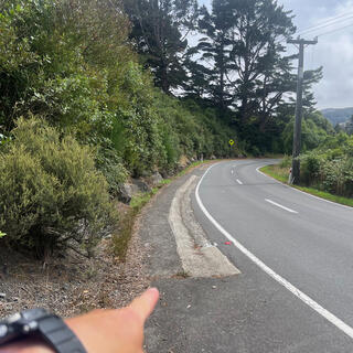 A foot wide strip of concrete on the left shoulder looks like a shallow drain.