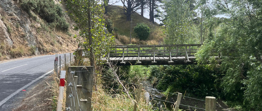 A private bridge crosses the river which runs alongside the road. 
