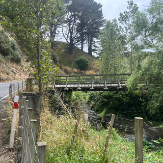 A private bridge crosses the river which runs alongside the road. 