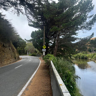An empty road and a slow flowing river.
