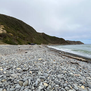 Waves break on the pebbly shore.