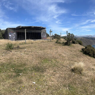 The gun emplacement is fenced off. A sign reads 'Danger. Unstable structure. Do not enter or attempt to climb on roof.'