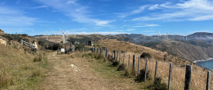 White three-bladed wind turbines cover the hills to the south.