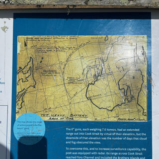 A blue signboard has a yellow map showing the range of the 6' guns.