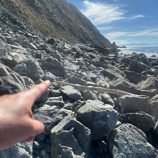 The full width of the coastline is covered with a thick jumble of small boulders.