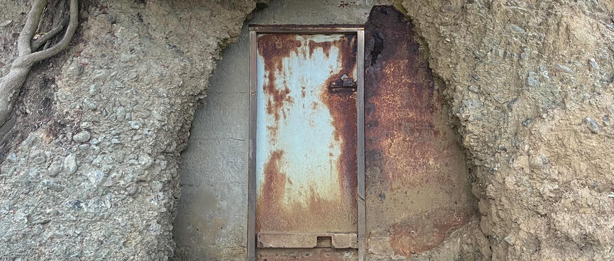 A metal door leads inside the hillside.