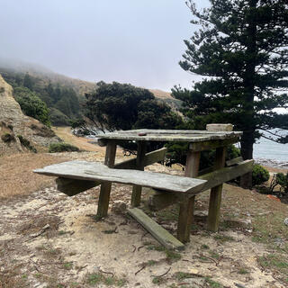 A rickity DIY picnic table near the two buildings.