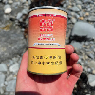 An empty can with some Chinese text and the words ʼHong Kongʼ and ʼDouble Happinessʼ.