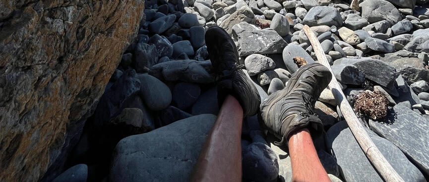 Legs and feet in the partial shadow of a rock.