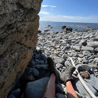 Legs and feet in the partial shadow of a rock.