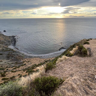 Looking down to a bay from the edge of a steep descent.