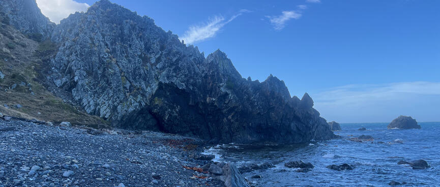 Jagged rock runs from the hills to the sea.