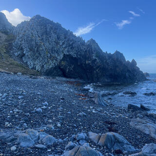 Jagged rock runs from the hills to the sea.