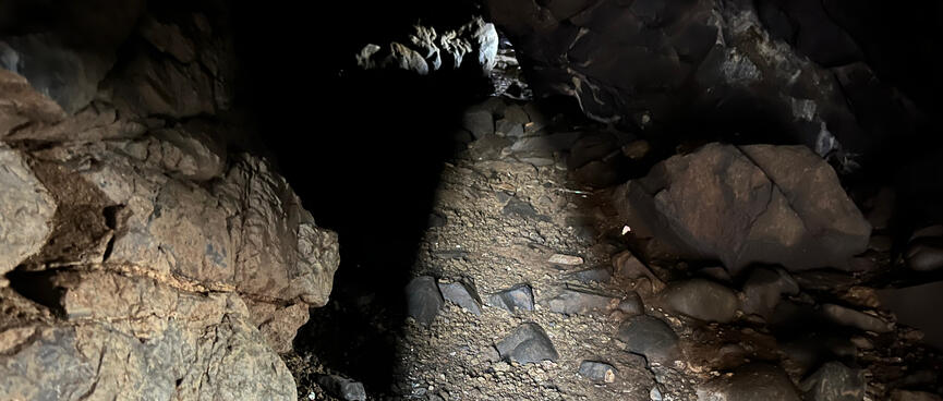 A beam of light partially illuminates a low passageway.