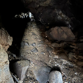 A beam of light partially illuminates a low passageway.