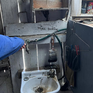 A metal tap above a porcelain basin.