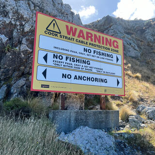 A large warning sign prohibits fishing and anchoring in the Cook Strait Cable Protection Zone.