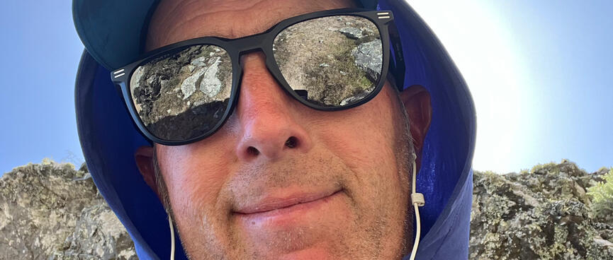 Me wearing a sunhat, mirror sunglasses and wired earphones.