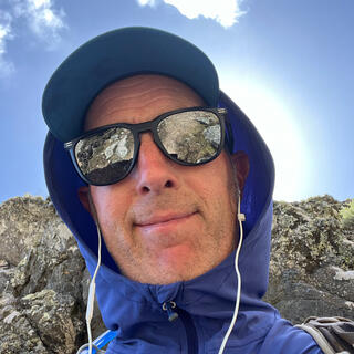 Me wearing a sunhat, mirror sunglasses and wired earphones.