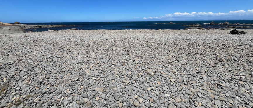 A pebbly beach and the sea beyond it.