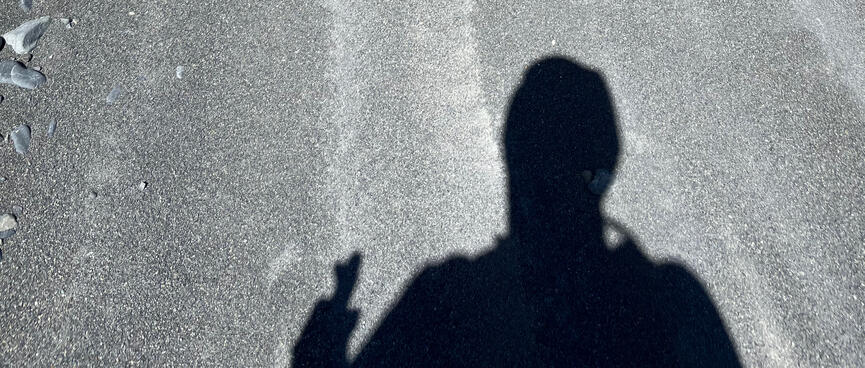 My shadow straddles a long depression in the fine beach shingle.